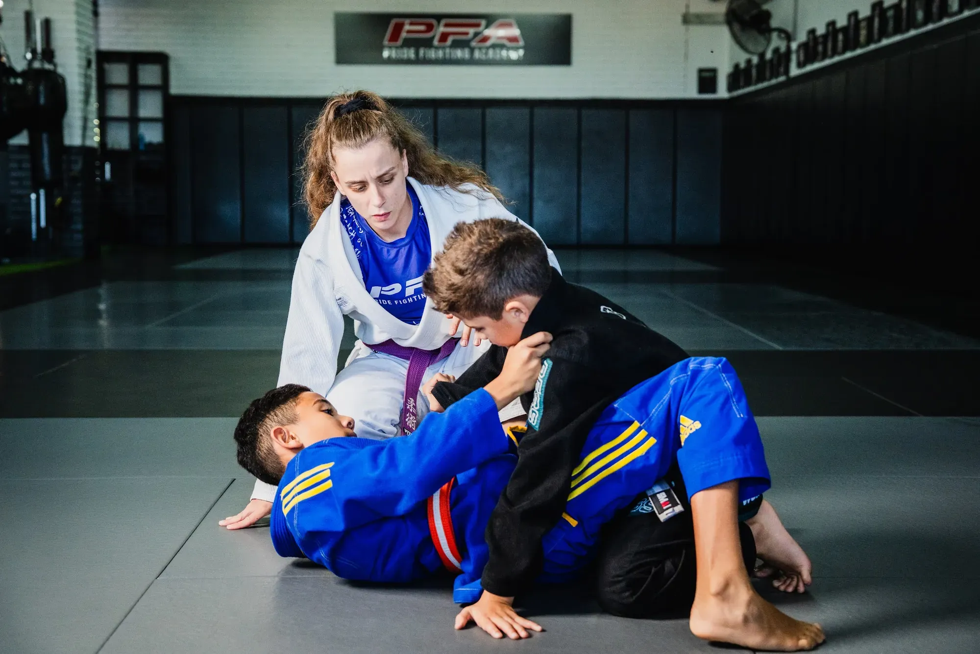 Kids practising Jiu-Jitsu with a coach